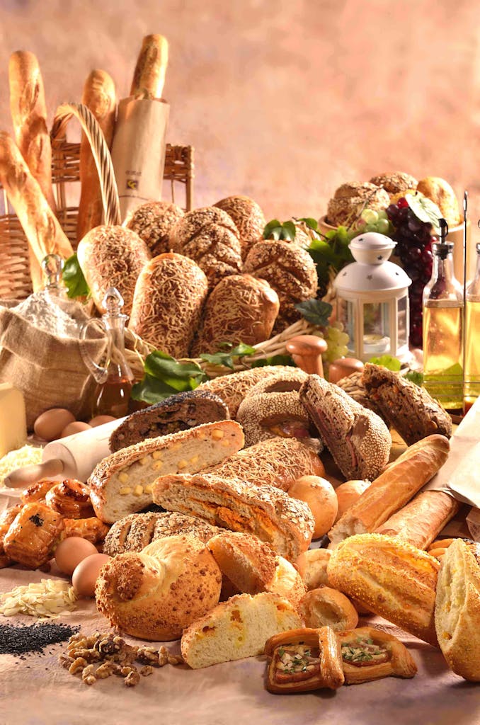 A variety of freshly baked artisan breads displayed with ingredients in a cozy rustic atmosphere.